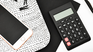 overhead shot of calculator and phone